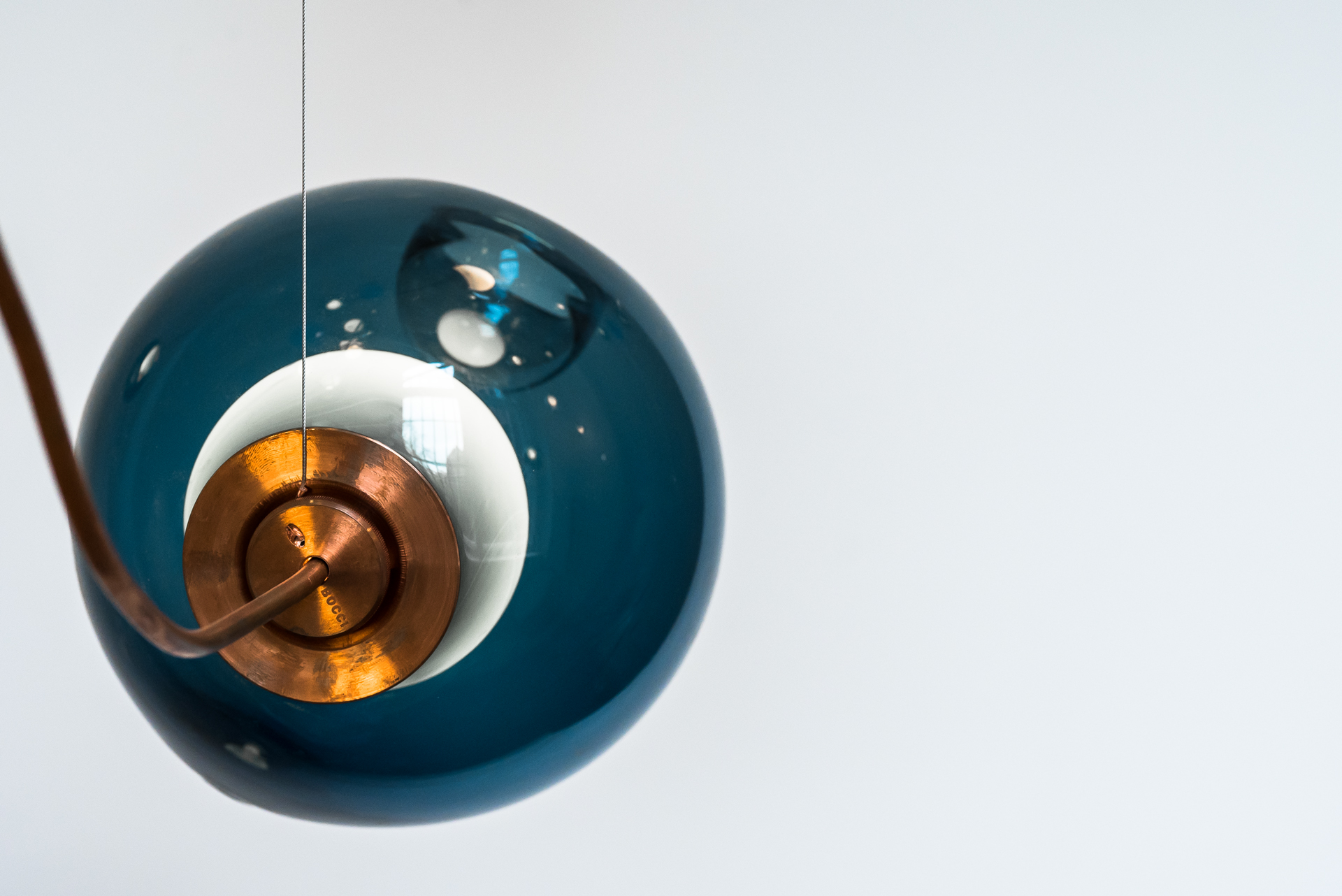  28.5c Pendant Light - 28.5c is a random configuration of five 28 pendants hung from a round canopy. The pendants are designed to hang in a random configuration at times clustering together and others trailing off. The result is an ambient installation or field of light.

28 is an exploration of specificity in manufacturing. Instead of designing form itself, here the intent was to design a system of making that yields form. Individual 28 pendants result from a complex glass blowing technique whereby air pressure is intermittently introduced into and then removed from a glass matrix which is intermittently heated and then rapidly cooled. The result is a distorted spherical shape with a composed collection of imploded inner shapes, one of which acts as a shade for the light source.

The 28 copper series provides a different compositional reading that results from shaping the copper tubing during installation. Pendants can be angled in any direction to provide a range of sculptural forms. The copper will weather and tarnish, registering the passage of time in its patina.

Standard 28s are made with clear glass exterior spheres and milk white interior lamp holder cavities, but pendants are available in any colour combination at extra cost. | Matter of Stuff